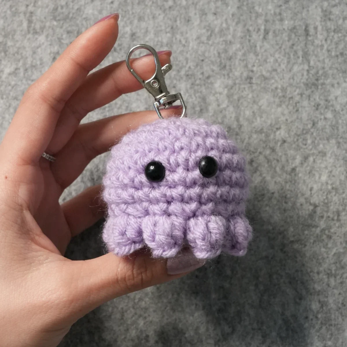 Small crocheted amigurumi keychain clipped to a bag