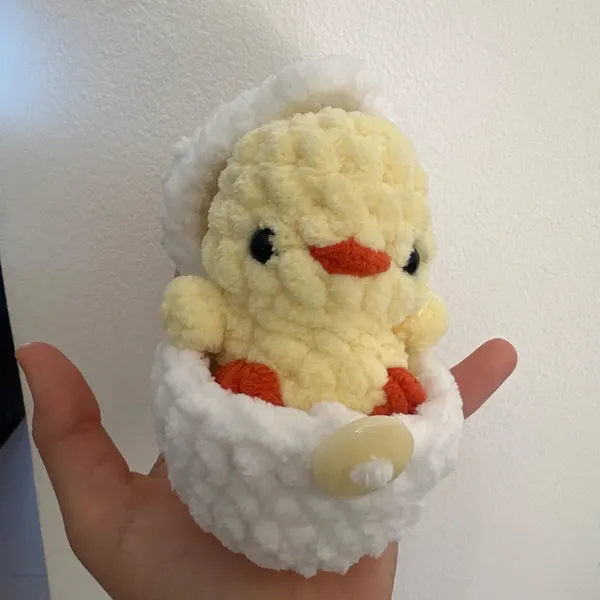 Mini crocheted dog hatching from its egg