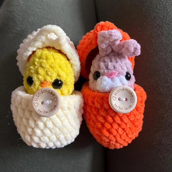 Tiny crocheted panda hatching from its egg
