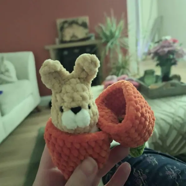 Mini crocheted bunny hatching from a carrot shelf